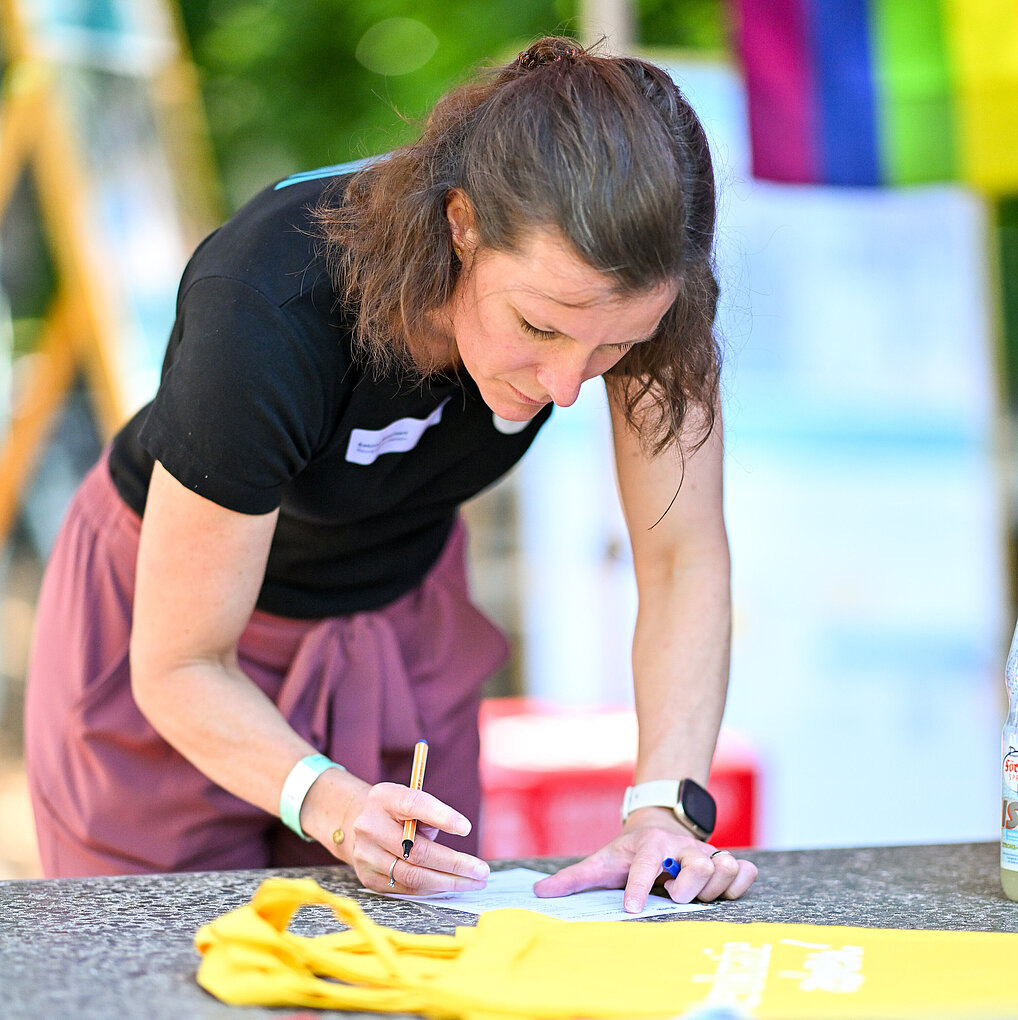 2025_06_14_Frau_füllt_Seminarunterlagen_aus